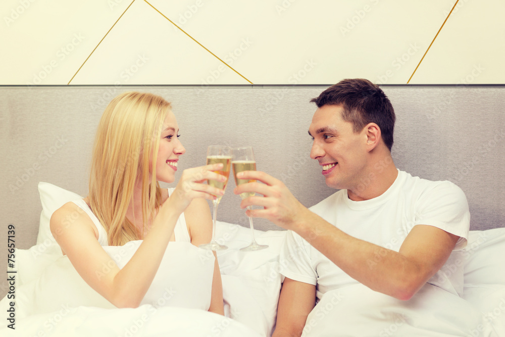 smiling couple with champagne glasses in bed smiling couple with champagne glasses in bed