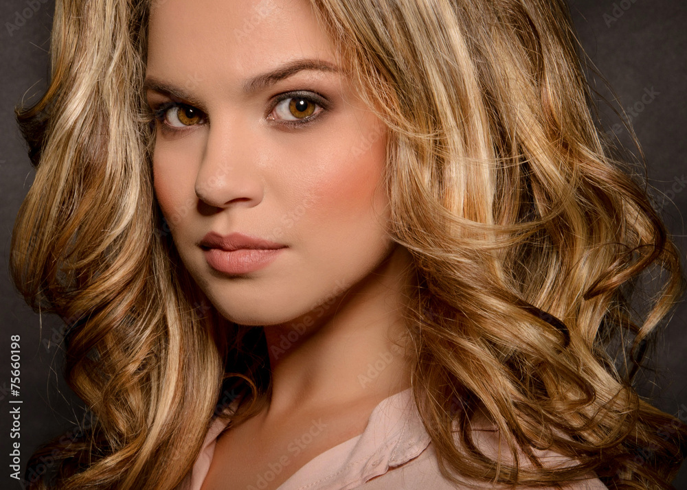 Blonde with a stylish haircut and styling on a dark background Blonde with a stylish haircut and styling on a dark background