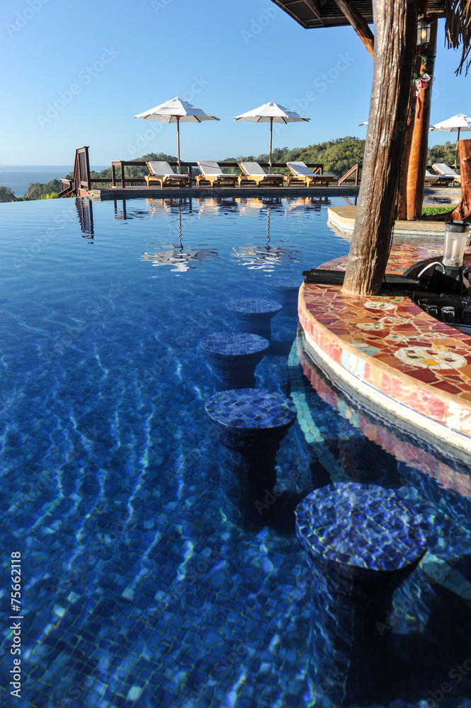 Obraz premium Swim-up bar in infinity pool in tropics