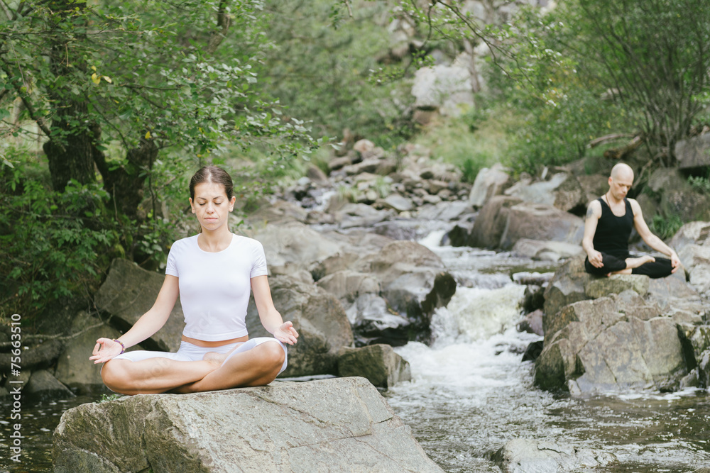 Woman and man doing yoga in nature Woman and man doing yoga in nature