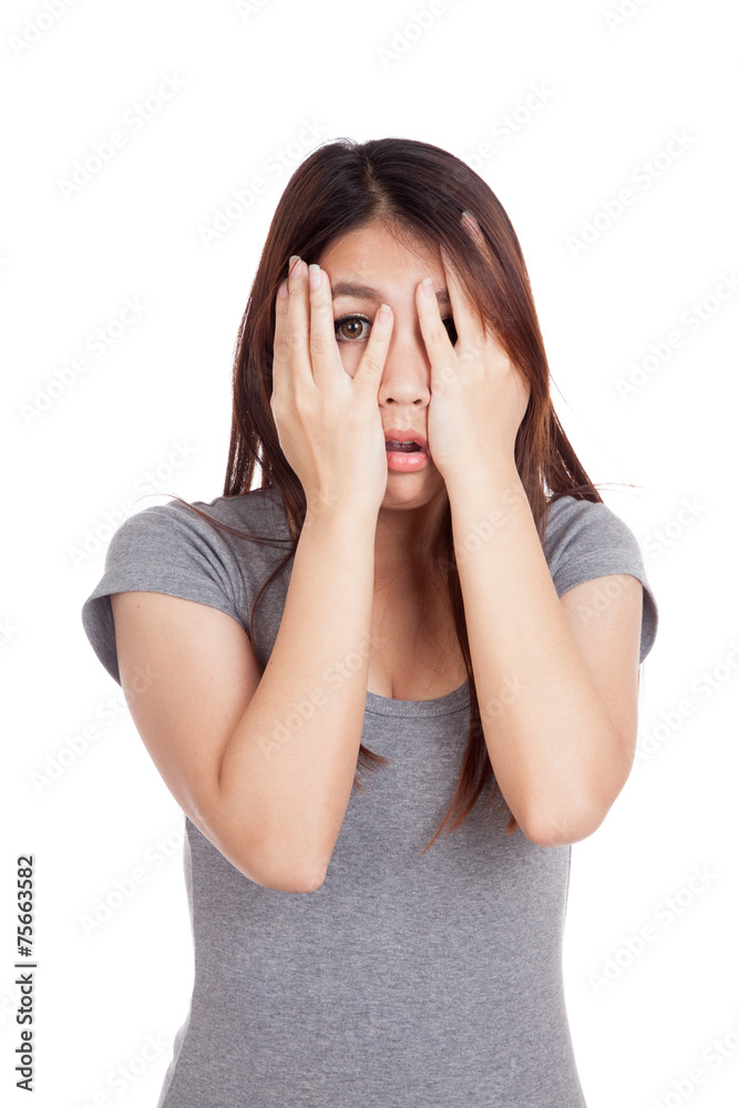 Young Asian woman peeking though her fingers Young Asian woman peeking though her fingers