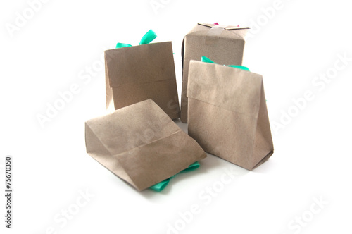 small gift wrapped in recycled paper with ribbon bow, isolated