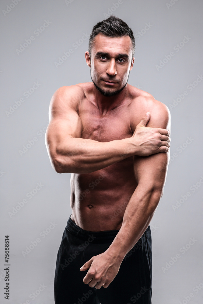Fototapeta premium Portrait of a muscular man touching his shoulder