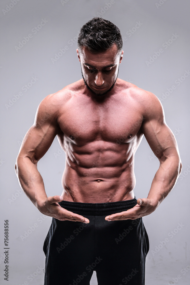 Portrait of a muscular man posing over gray background Portrait of a muscular man posing over gray background
