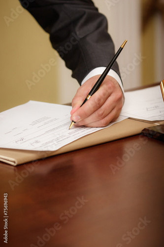 Closeup of a businessman writing on agenda left hand