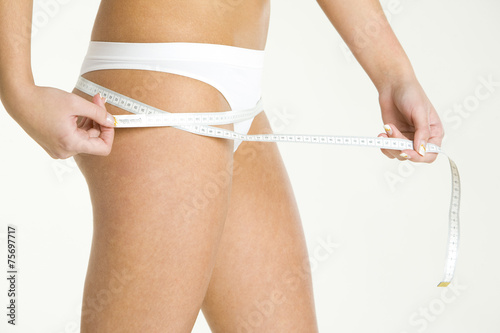 detail of woman wearing underwear with tape measure