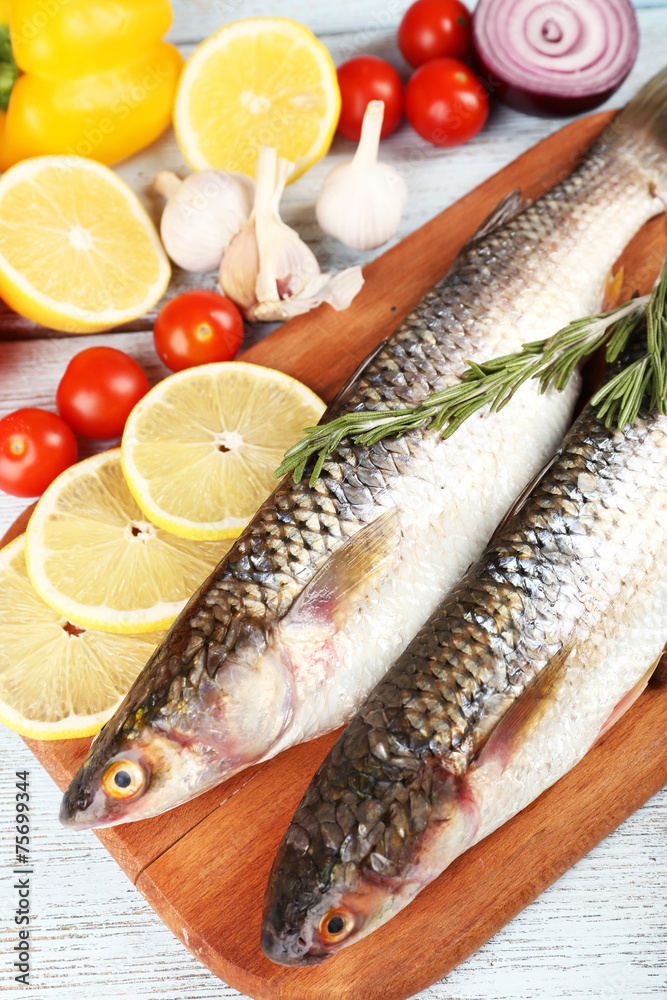 Fresh raw fish and food ingredients on table Fresh raw fish and food ingredients on table
