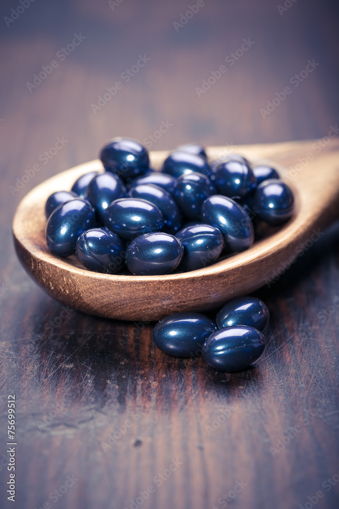 Cod liver oil omega 3 gel capsules isolated on wooden background Cod liver oil omega 3 gel capsules isolated on wooden background