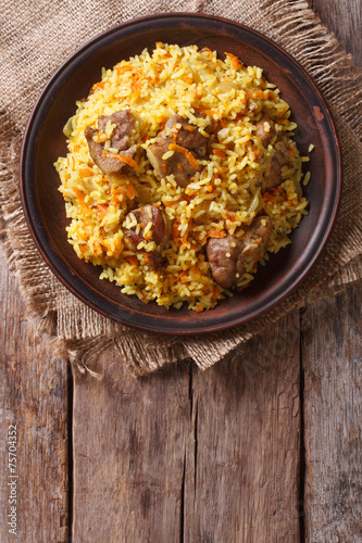 Rice with meat and vegetables on an old table  vertical top view