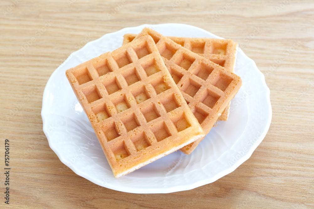 Delicious sweet waffle in ceramic plate on white plate Delicious sweet waffle in ceramic plate on white plate