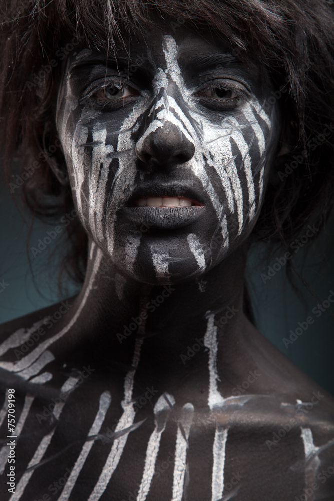 dark portrait of woman in black paint with white smudges 
