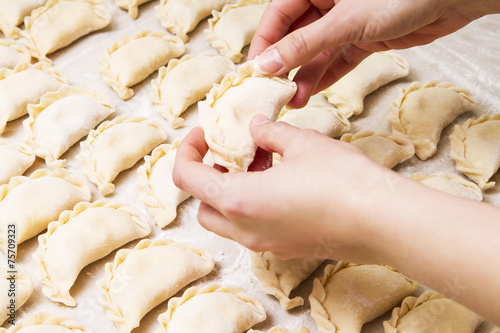 Dumplings. Dough with illing on the cook's hands. photo