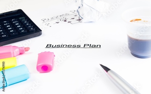 business plan words near highlighters, calculator and coffee