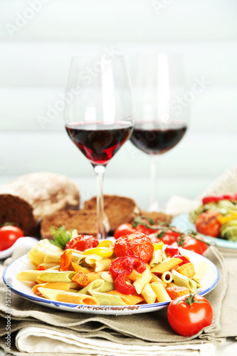 Pasta salad with vegetables and two glasses of red wine