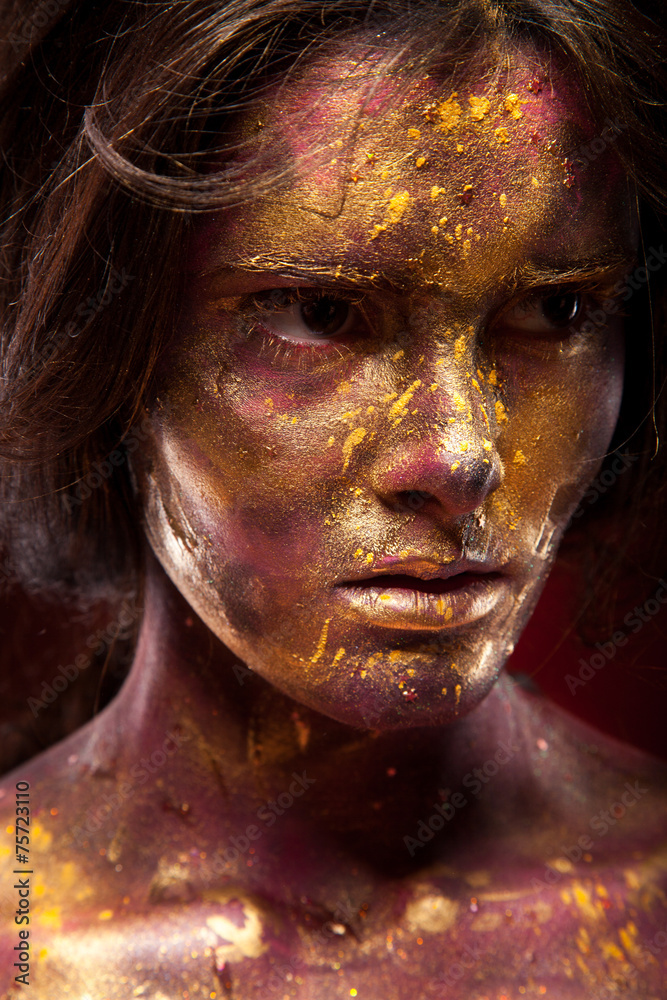 Girl with gold paint on face with face art and body art Girl with gold paint on face with face art and body art