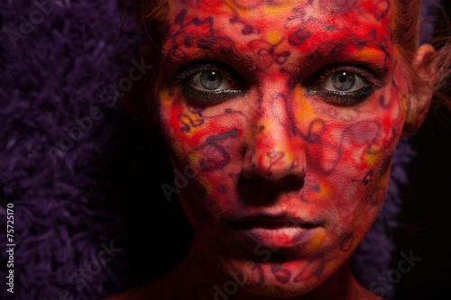Fashion Model Portrait with red face art. Body art.Paint on face