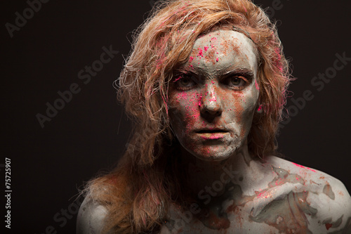 Portrait of young woman covered in healing clay. Face art.