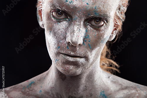 Woman with silver paint on face. Statue in liquid metal posing