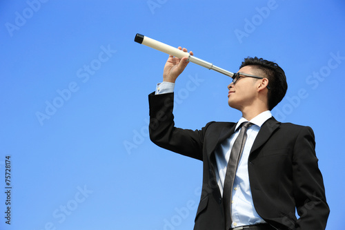 Businessman with telescope looking forward