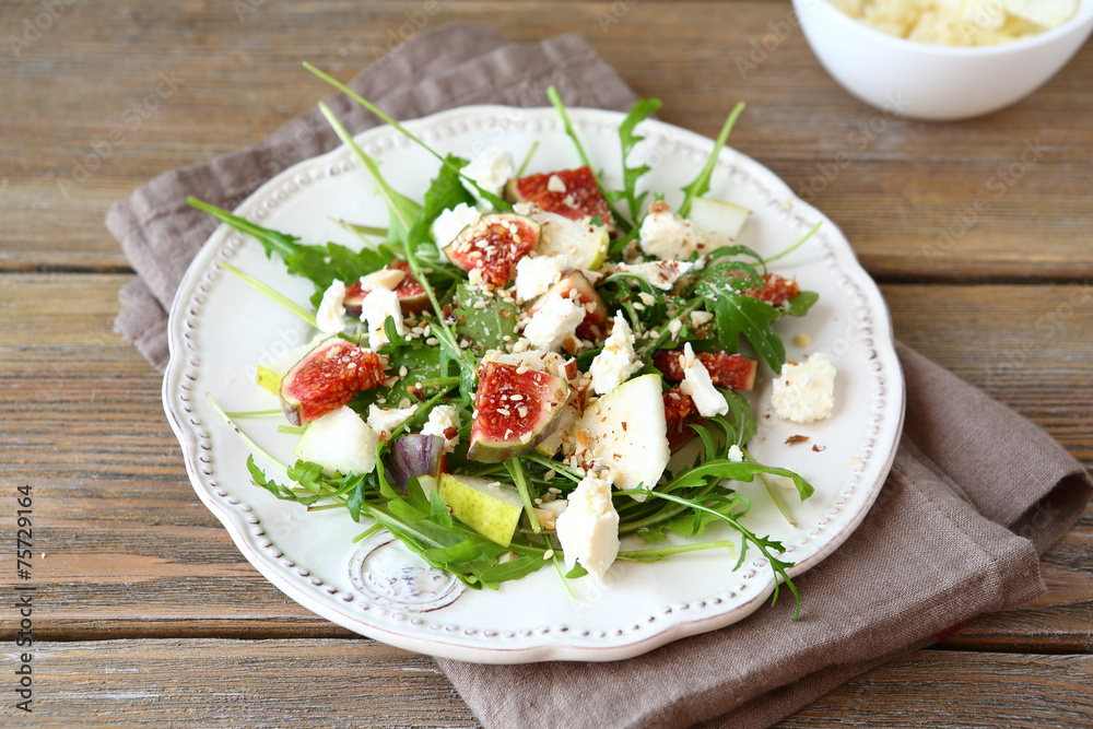 Delicious salad with arugula, sliced ​​pears and figs