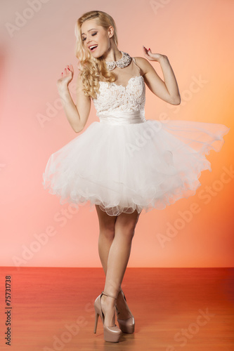 young woman in an elegant white dress posing in studio