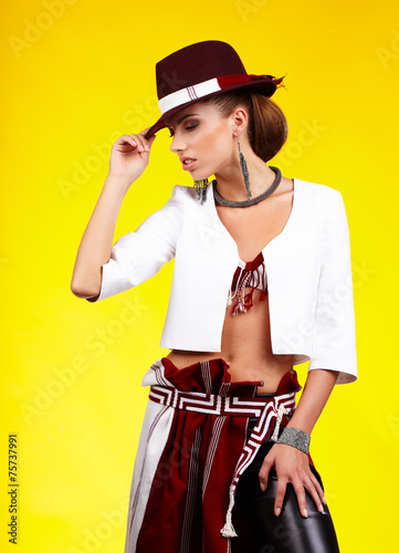 Fasionable woman in a hat over yellow background photo