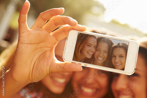 Female Friends On Holiday Taking Selfie With Mobile Phone