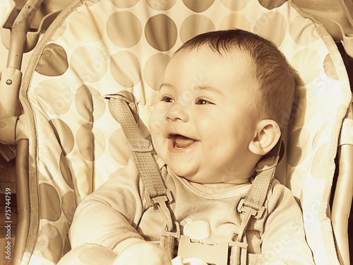 Portrait of small caucasian baby boy sitting at the chear photo