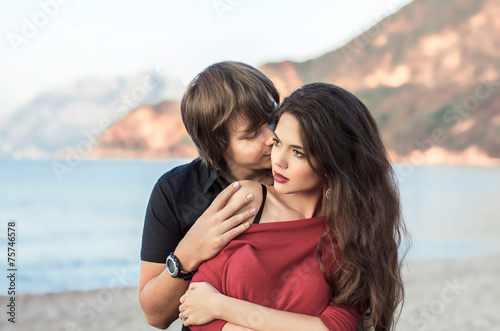 Kissing couple in love outdoors close-up portrait. Man embracing