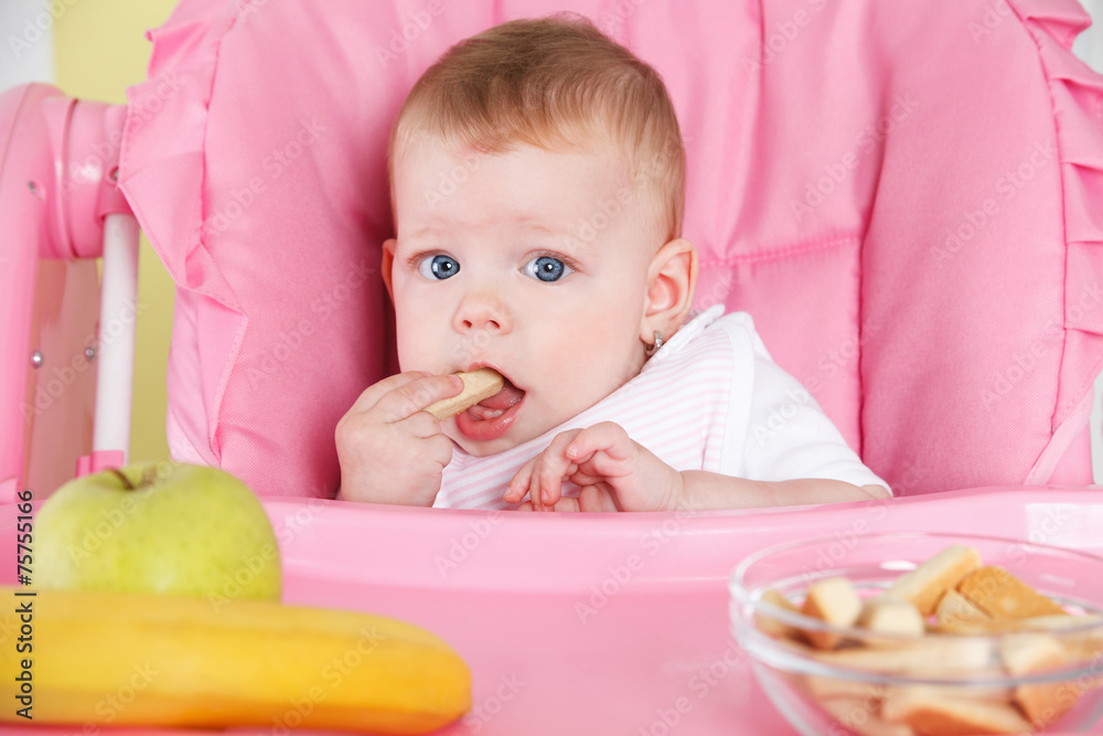 Portrait of a baby girl eating alone Portrait of a baby girl eating alone