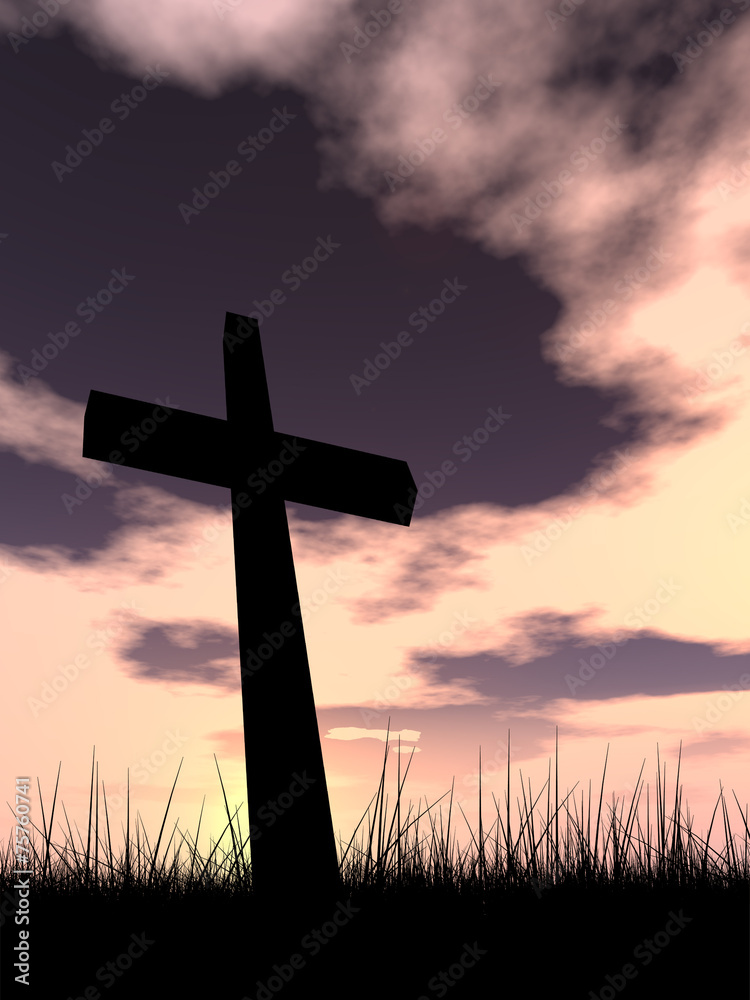 Black cross in grass ar sunset