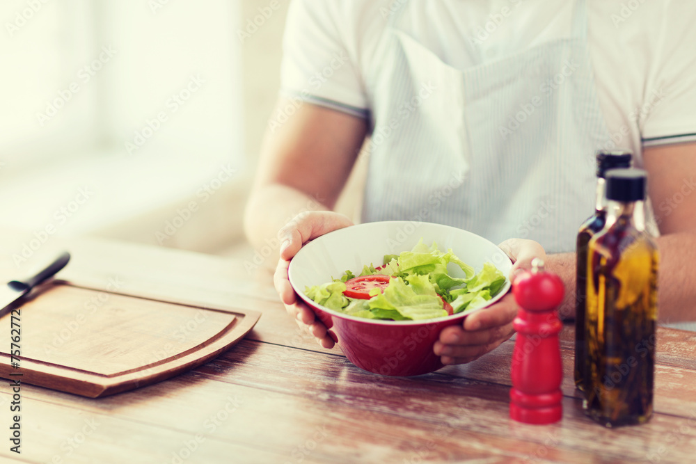 close of male hand holding a bowl with salad close of male hand holding a bowl with salad