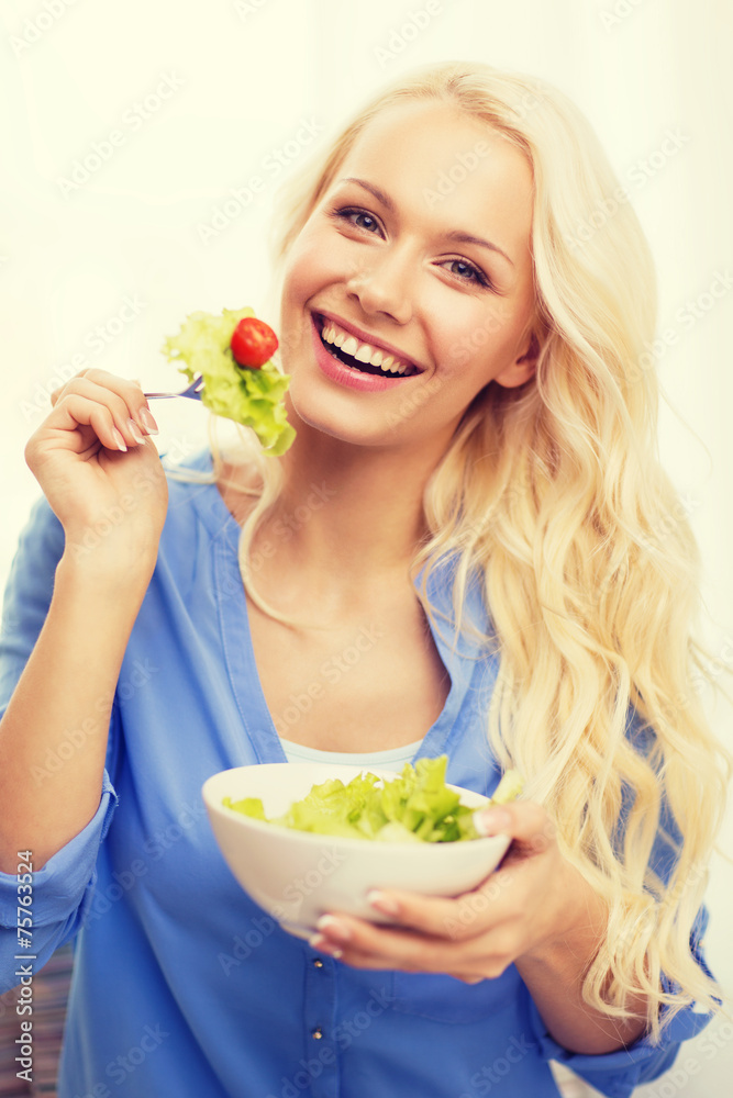 smiling young woman with green salad at home smiling young woman with green salad at home