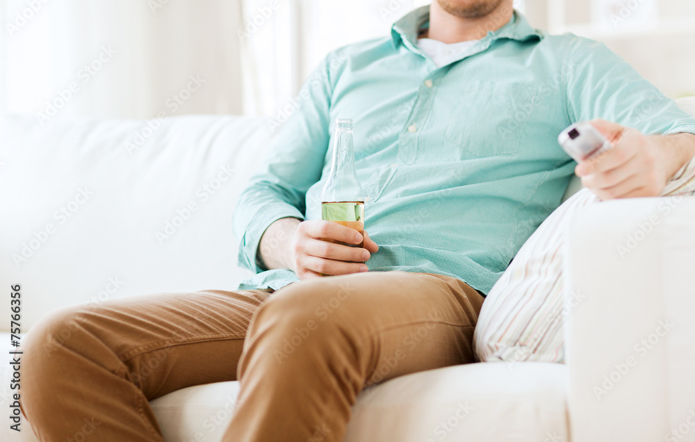 man with beer and remote control at home man with beer and remote control at home