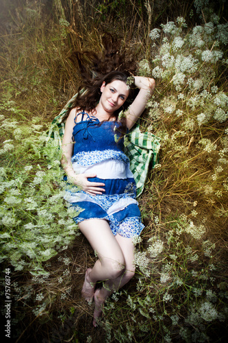 smiling pregnant young woman lying on grass © pirotehnik