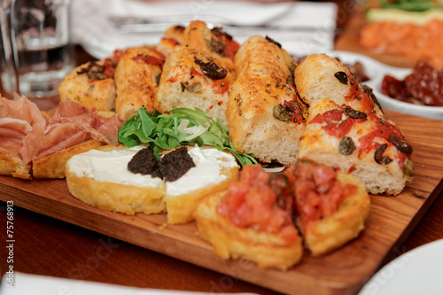 Italian appetizers on wooden plank