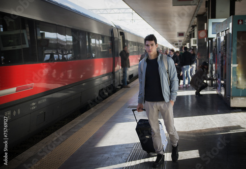 Handsome young male traveler in train station