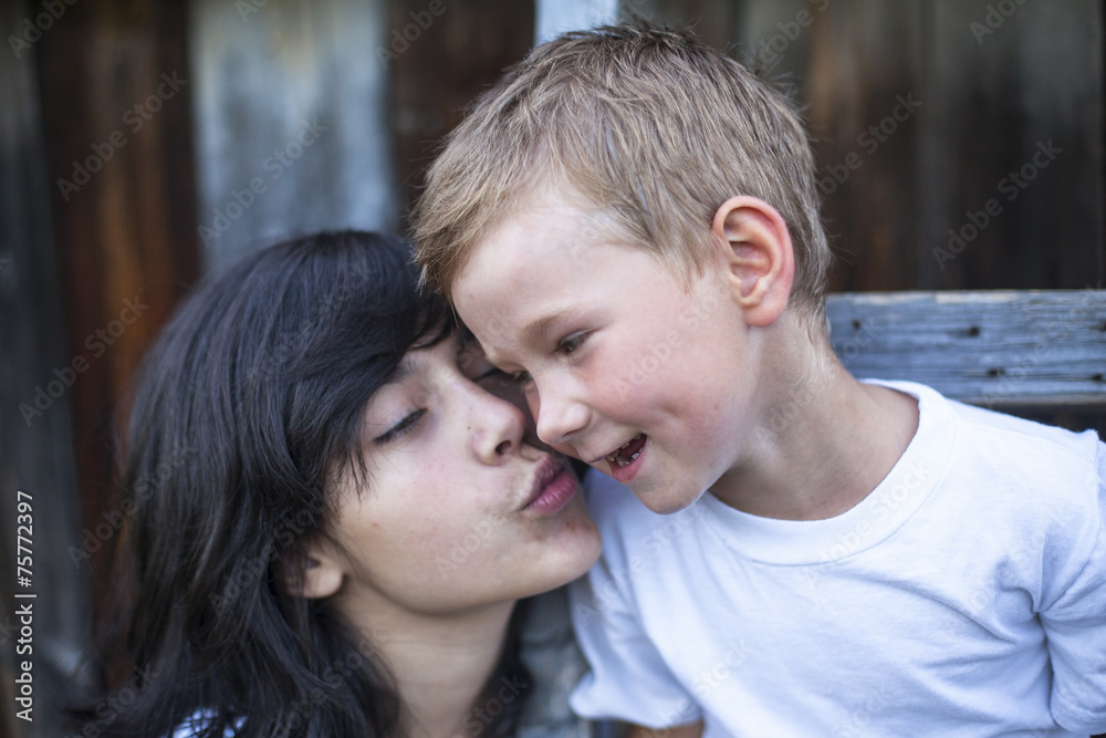 Teen girl playing with his younger brother outdoors. Teen girl playing with his younger brother outdoors.