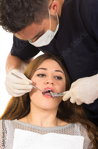 young male dentist examinig beautiful girl's teeth