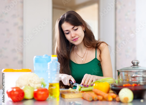  beautiful housewife cutting vegetables at kitchen