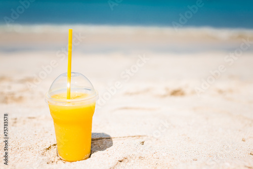 Mango cocktail on tropical beach background