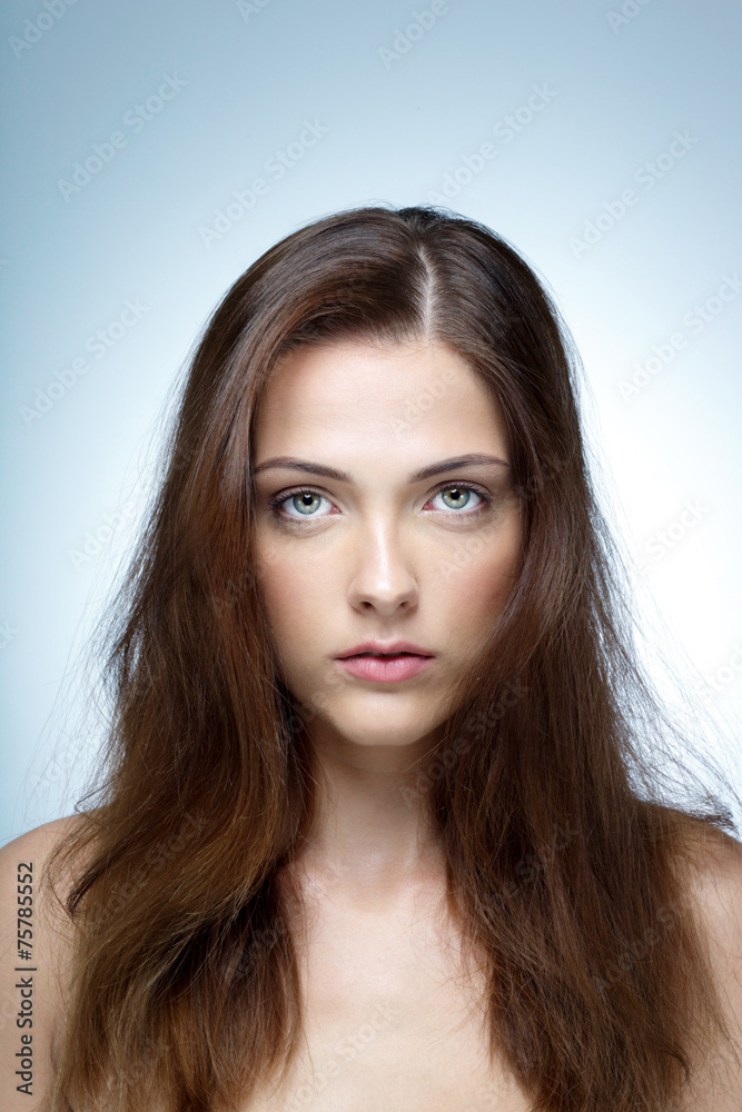 Closeup portrait of a beautiful woman over blue background Closeup portrait of a beautiful woman over blue background