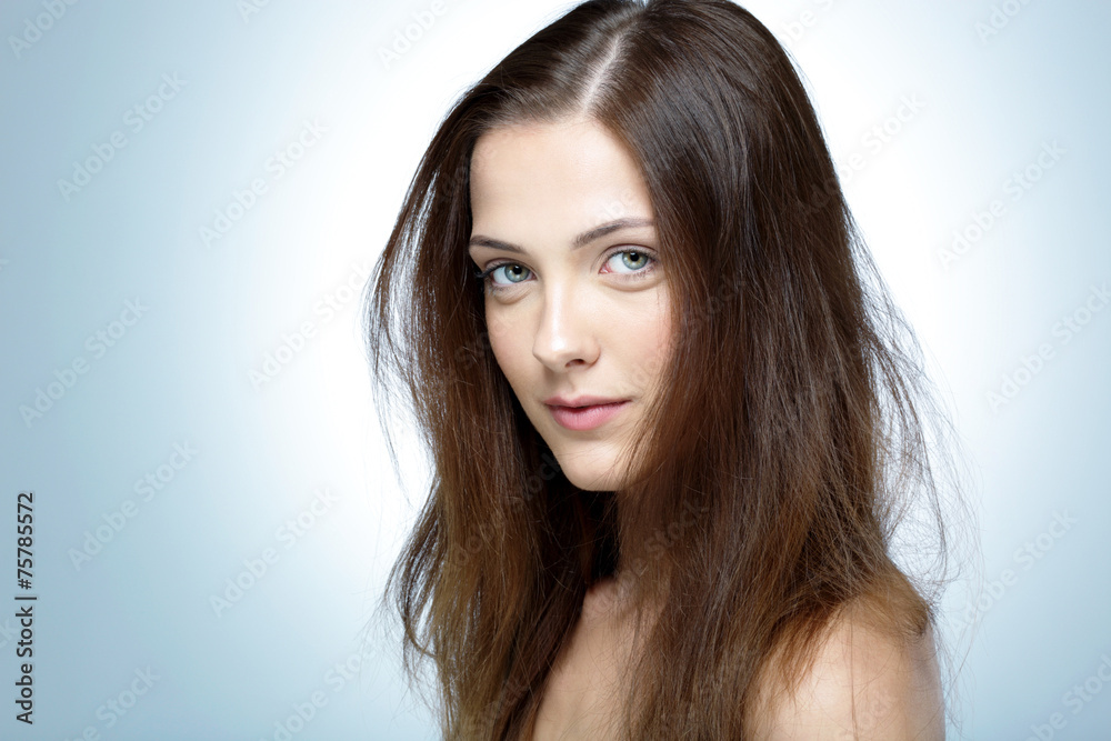 Closeup portrait of a young cute girl over blue background Closeup portrait of a young cute girl over blue background
