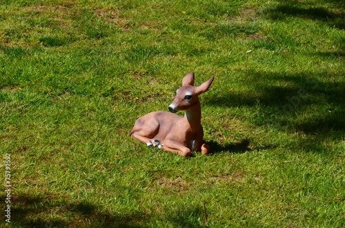 Decorative fake deer laying on lawn photo
