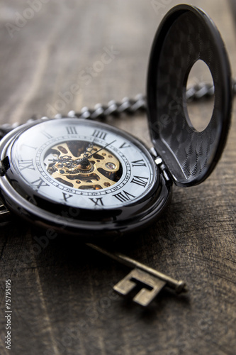pocket watch over grunge wooden table
