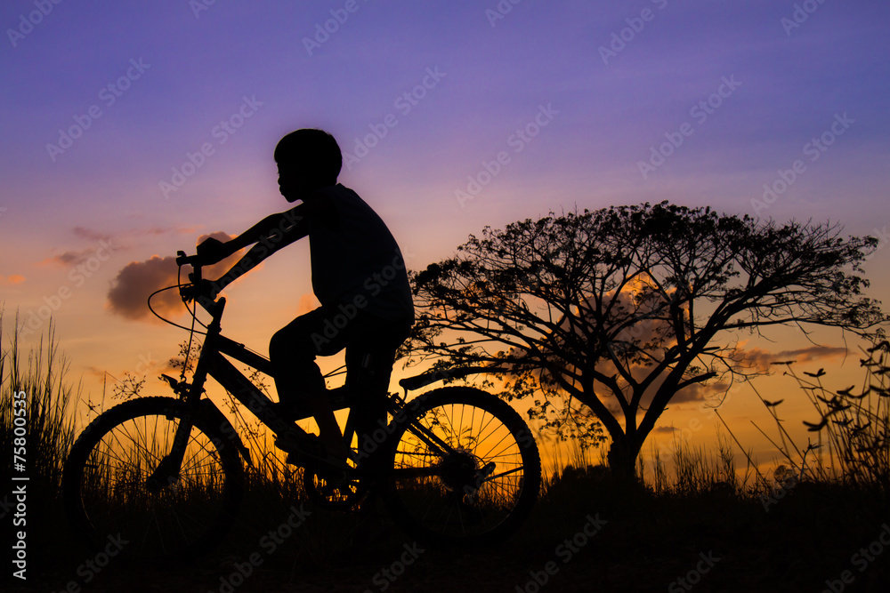 Silhouette of a children and bicycle on sunset Silhouette of a children and bicycle on sunset