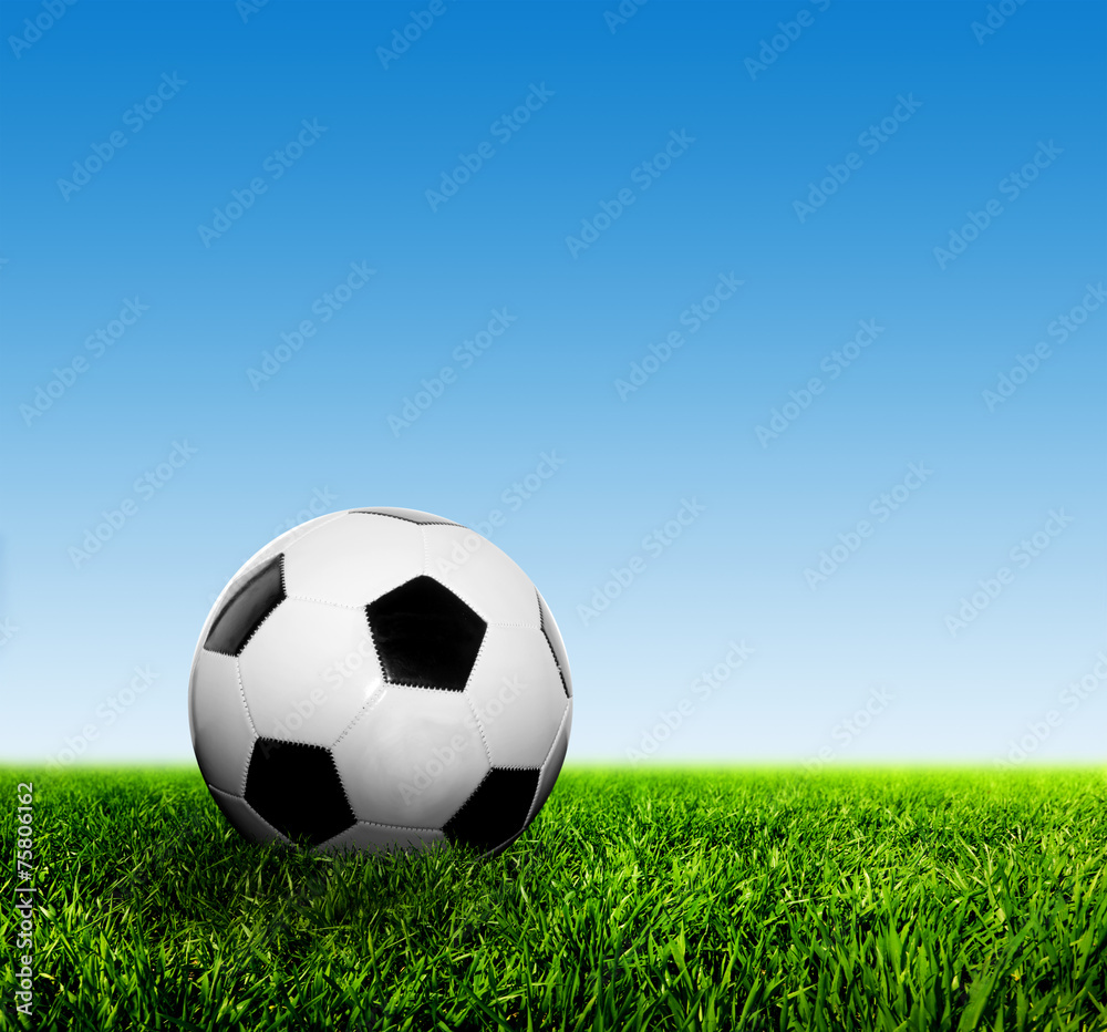 Fototapeta premium Ball on grass against blue sky. Football, soccer.