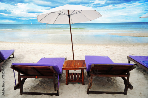 Beach chairs under an umbrella in Hua-Hin beach