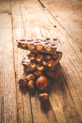 Chocolate and nuts on a wooden table in vintage style