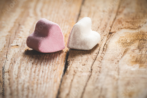 The pink and white heart on a wooden rustic table as background